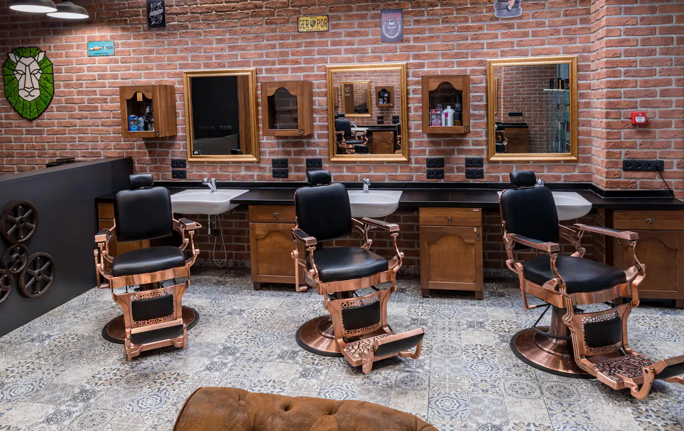 The shop floor with three chairs, brass mirrors and patterned tiles